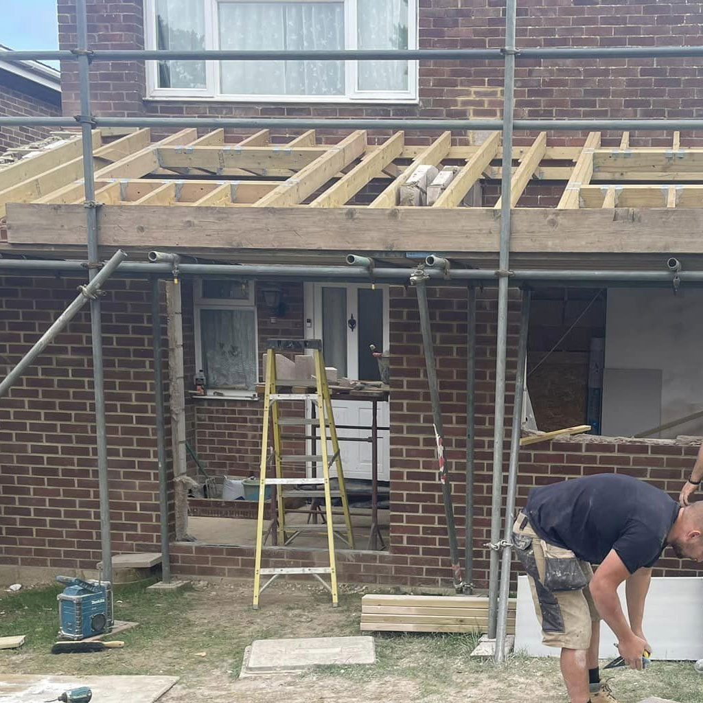 New timber joists spanning an opening with the scaffold and ladder still in place, part-way through the structural work